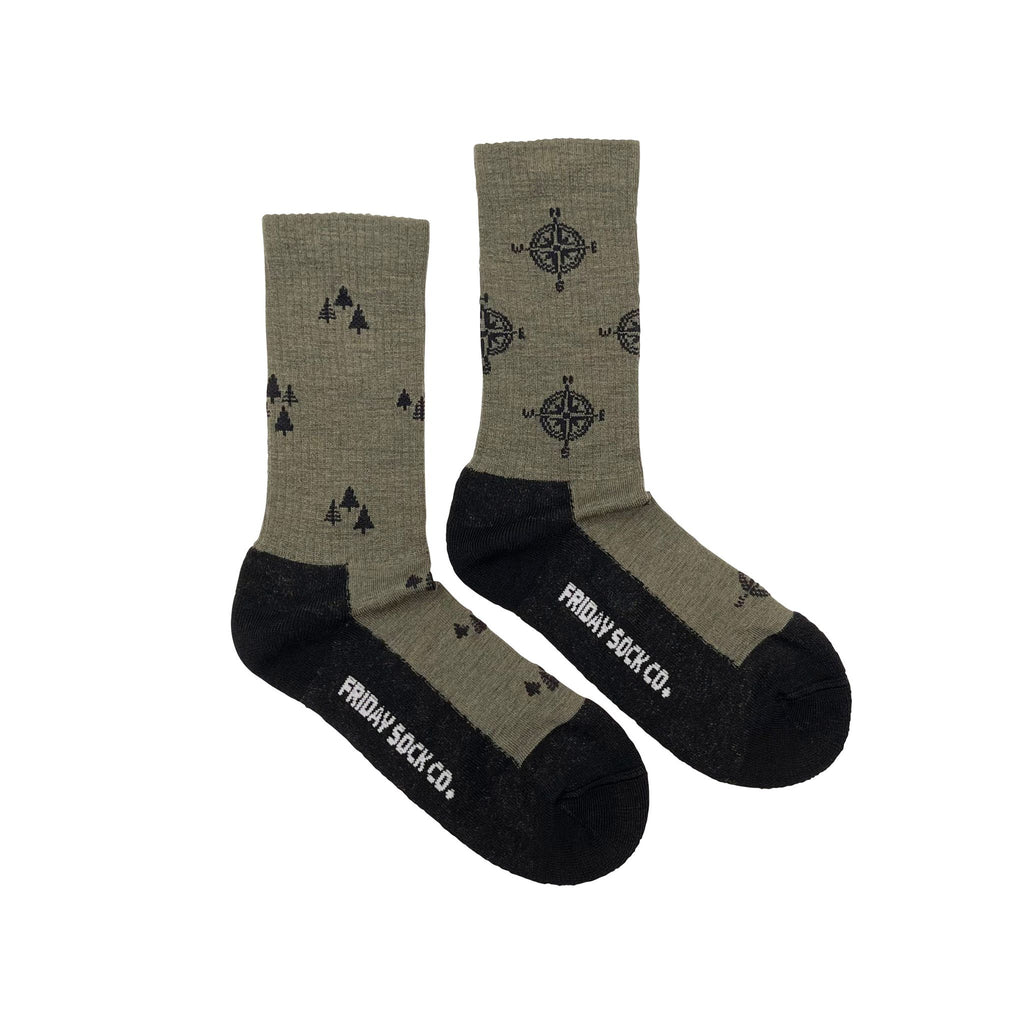Green wool socks with a brown sole and compass and tree patterns